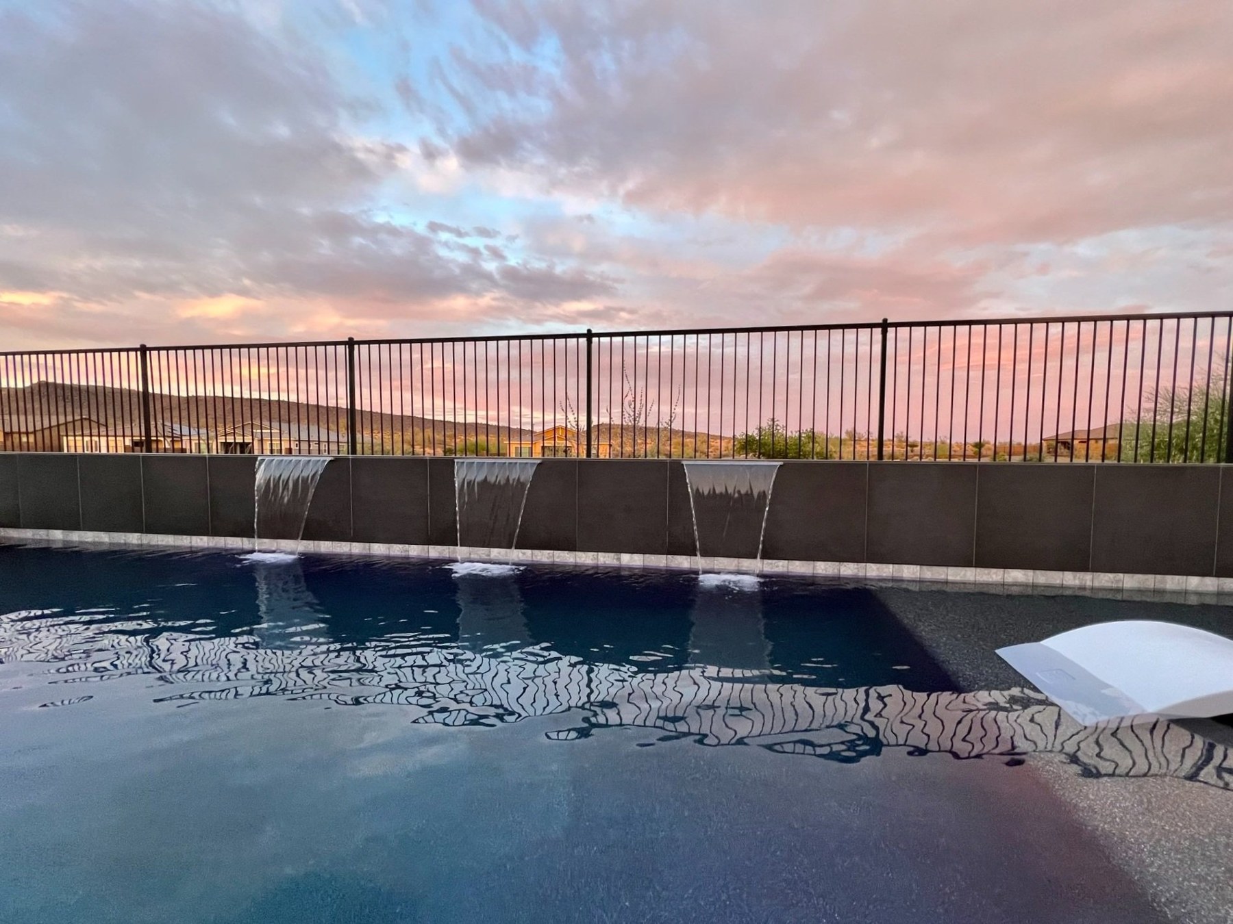 Completed pool with water features at sunset